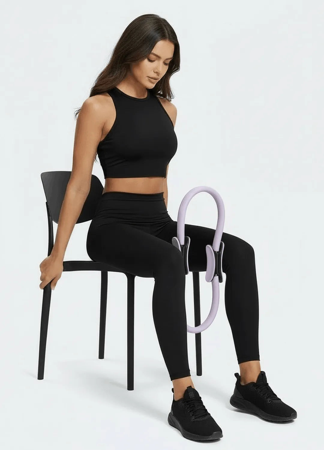 Femme utilisant anneau pilates violet sur chaise